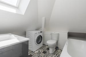a bathroom with a washing machine and a toilet at Charmant appartement proche centre-ville plage in Saint-Nazaire +10 photos