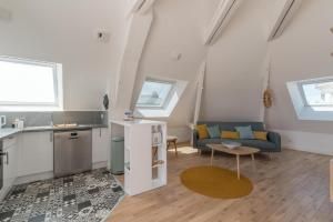 a kitchen and living room with a couch and a table at Charmant appartement proche centre-ville plage in Saint-Nazaire