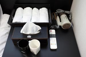 una caja de papel higiénico y un mando a distancia sobre una mesa en Ekonomy Hotel Myeongdong Premier, en Seúl