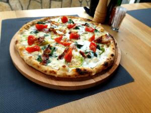 a pizza on a wooden cutting board on a table at Maglian Forest Retreat in Divčibare