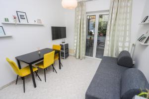 sala de estar con sofá, mesa y sillas en Apartments Silvano, en Poreč