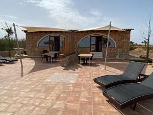 a house with a patio with chairs and a table at VILLA CHANTAL in Lampedusa