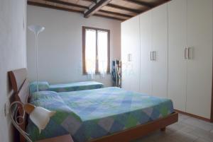 a bedroom with a bed and white cabinets at Appartamenti LEVANTE e LIBECCIO in Follonica