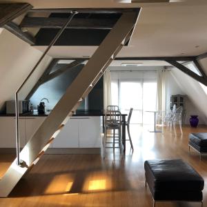 an attic kitchen and living room with a staircase at DUPLEX 15 in Colmar