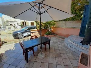 a table with an umbrella on a patio at Appartamenti 34 Spiaggia di Pescoluse in Marina di Pescoluse
