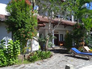 a house with a blue bench in front of it at family house hotel kuta in Kuta Lombok
