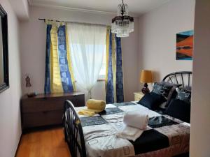 a bedroom with a bed and a window with curtains at Casa da Isilda in Praia da Barra