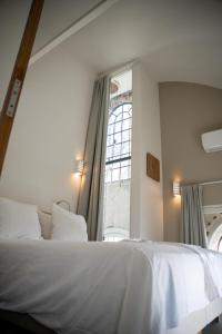 een slaapkamer met een wit bed en een raam bij Nobel - Suites in Ballum
