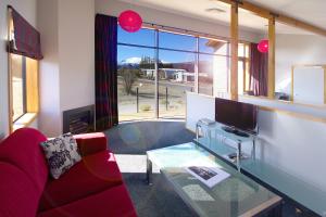 a living room with a red couch and a glass table at Parkview Apartments in National Park