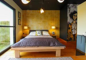 a bedroom with a bed and a painting on the wall at La Villa des Temps Modernes in Albi +22 photos