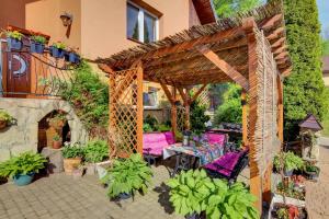 une pergola avec une table et des chaises dans un jardin dans l'établissement Pokoje Gościnne Mena, à Muszyna