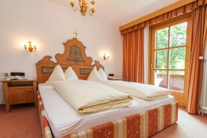 1 dormitorio con 1 cama grande con almohadas blancas en Dandler - Zimmer und Ferienwohnungen, en Fieberbrunn
