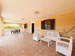a large room with a patio with tables and chairs at VILLA REGINA - Sperlonga Vertice Rooms in Sperlonga