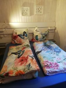 two beds sitting next to each other with floral pillows at Hasenstall in Rehburg-Loccum