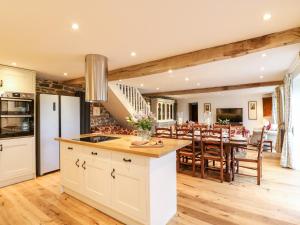 a kitchen and dining room with white cabinets and a table at Lake View in Crediton