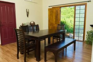 a dining room with a wooden table and chairs at Biosphere in Coonoor