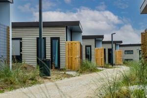 una fila de casas con puertas de madera en una carretera en EuroParcs De Koog, en De Cocksdorp