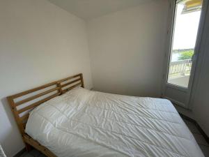 a white bed in a room with a window at Deux pièces rénové avec terrasse, parking privé à Port Camargue - FR-1-250-173 in Saint-Mélany