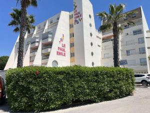 ein Gebäude mit einem Busch vor einem Gebäude in der Unterkunft Deux pièces rénové avec terrasse, parking privé à Port Camargue - FR-1-250-173 in Saint-Mélany