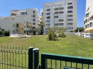 a green fence in front of a large building at Deux pièces rénové avec terrasse, parking privé à Port Camargue - FR-1-250-173 in Saint-Mélany