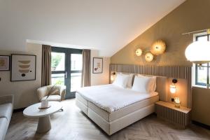 a hotel room with a bed and a chair at Boutique Hotel Helder I Kloeg Collection in Renesse