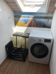 eine Waschmaschine in einem Zimmer mit Wandgemälde in der Unterkunft Gästehaus Beranek in Marktoberdorf