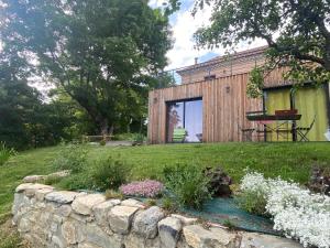 um jardim com uma parede de pedra e uma casa em La petite maison Basse Correo 