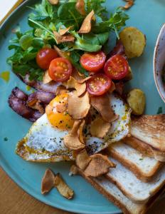 un plato azul con huevos y una ensalada y tostadas en Aksjemøllen - by Classic Norway Hotels en Lillehammer