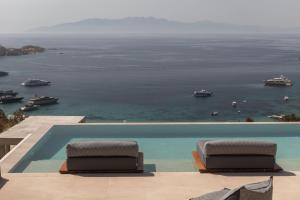 a swimming pool with a view of the ocean at Calma Suites Mykonos in Psarou
