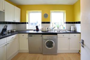 a kitchen with a washing machine and yellow walls at Pass the Keys 1BR Modern Beautiful House Pass the Keys in Cambridge