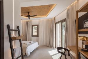 Calma Suites Mykonos في بسارو: غرفة نوم مع سرير بطابقين ونافذة