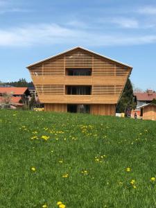 ein Gebäude auf einem Grasfeld in der Unterkunft Alpin Chalet Trinkl - adults only ab 16 Jahren in Bad Wiessee