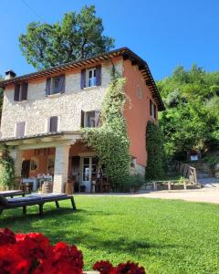Uma casa italiana com um banco à frente. em B&B L'Usignolo em Ascoli Piceno