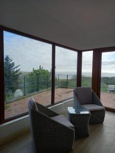a living room with two chairs and a large window at Two bed bungalow with sunroom and stunning views in Killybegs