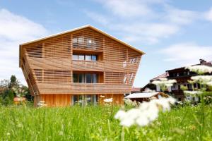 una casa de madera en un campo de hierba en Alpin Chalet Trinkl - adults only ab 16 Jahren en Bad Wiessee