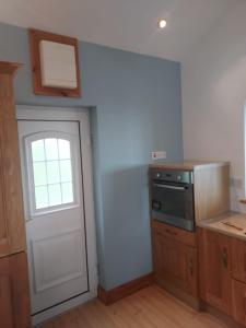 une cuisine avec une porte blanche et une fenêtre dans l'établissement Two bed bungalow with sunroom and stunning views, à Killybegs