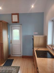 an empty kitchen with a door and a counter top at Two bed bungalow with sunroom and stunning views in Killybegs