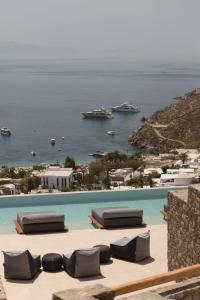 Calma Suites Mykonos في بسارو: مسبح مطل على المحيط والقوارب