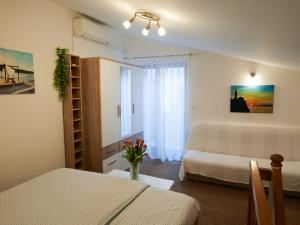 een kleine kamer met een bed en een tafel met bloemen bij Apartment or room at Irena's in Piran