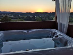 a bath tub sitting on a balcony with the sunset at Apartment Viksa with Jacuzzi in Zagreb