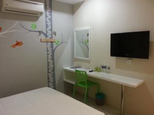 a room with a desk and a tv in a room at Hotel Strawberry Fields in Petaling Jaya