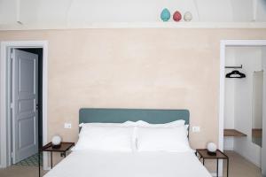 a bedroom with a white bed with two tables at Palazzo Garibaldi - Luxury Suites in Galatina