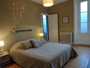 a bedroom with a large bed with lights on the wall at La Maison de Jeanne, maison d'hôtes in Thiézac