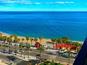 a view of a beach with palm trees and the ocean at Benalmadena ALOHA PLAYA SEA VIEW LOFT in Benalmádena