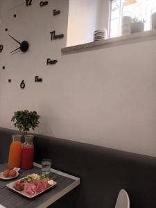 Hotel Porto Di Roma في تشيفيتافيكيا: طاولة مع طبق من الطعام وساعة على الحائط