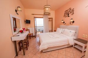 a bedroom with a bed and a table and a desk at Golden Sun in Agios Ioannis Pelio
