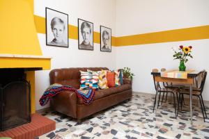 sala de estar con sofá de cuero marrón y mesa en Casa vacanze con giardino - Twiggy's House, en SantʼAntìoco