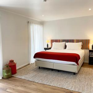 a bedroom with a large bed with a red blanket at Villa Alter in Alter do Chão