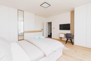 biała sypialnia z łóżkiem i biurkiem w obiekcie Bella Vista by Mountain ways w mieście Loučná pod Klínovcem