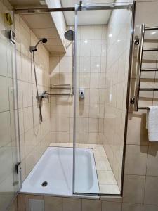 a shower with a bath tub in a bathroom at 612КМ in Stryi